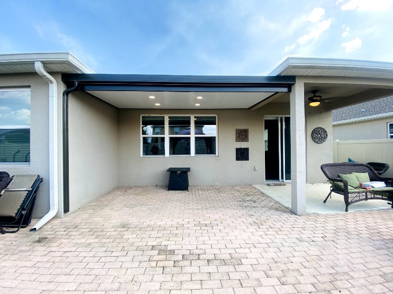 gray home with pavers and patio furniture